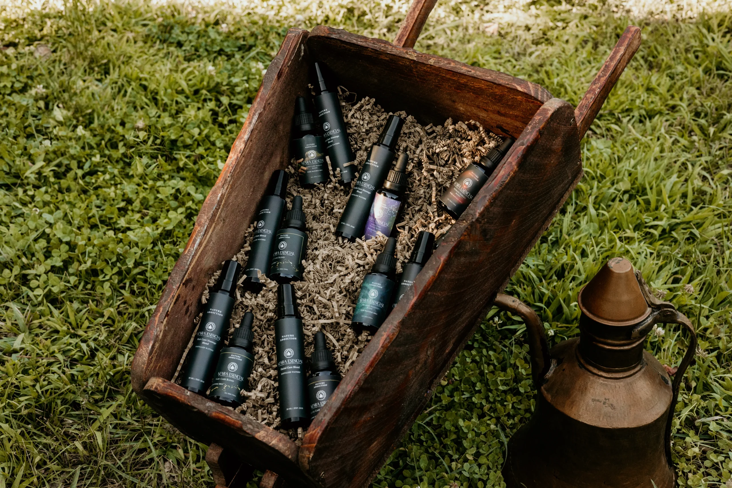 cinematic image in the garden for some of azara natural products (oil bottles inside an old wooden wheelbarrow)