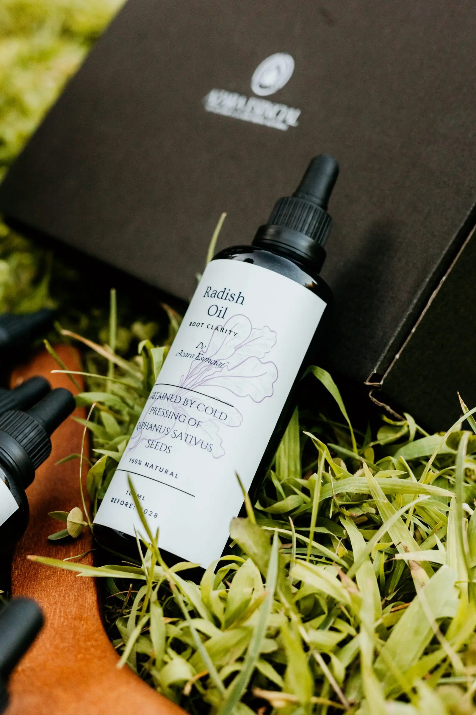 bottle of radish oil lying on the black box of azara natural in professional shot in the nature BY azara natural