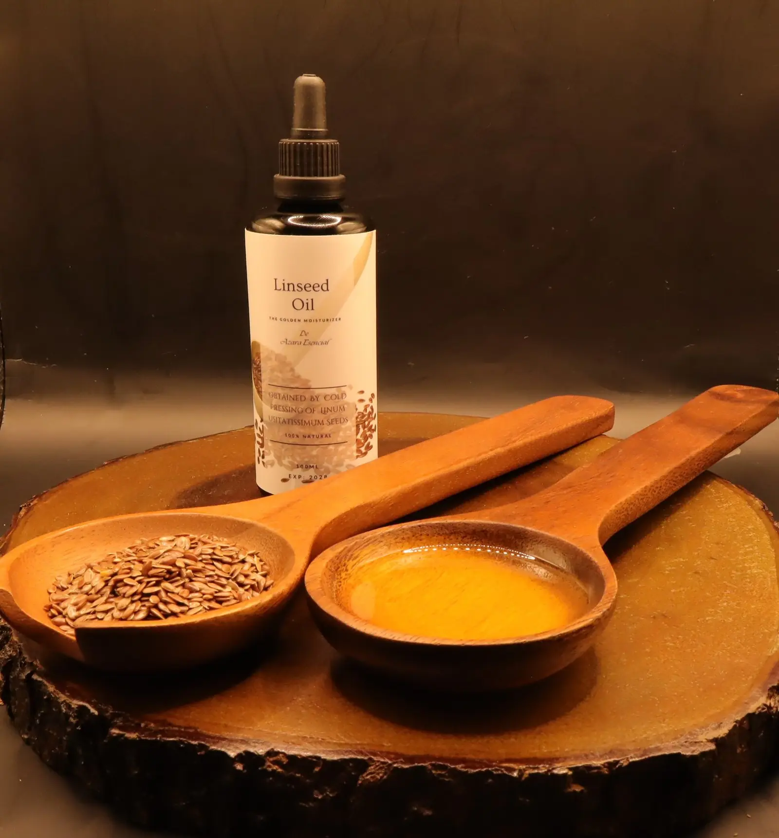 linseed oil By azara natural with wooden spoon of the oil and another full of linseeds with black background and circular wooden stand