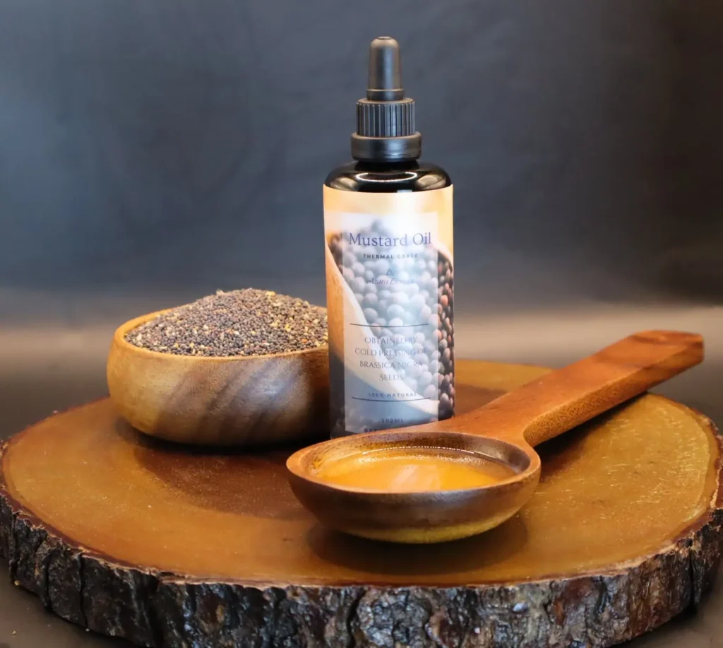 Mustard-Oil product shot with black background with wooden spoon full of the oil and a wooden cup full of mustard seeds BY azara natural
