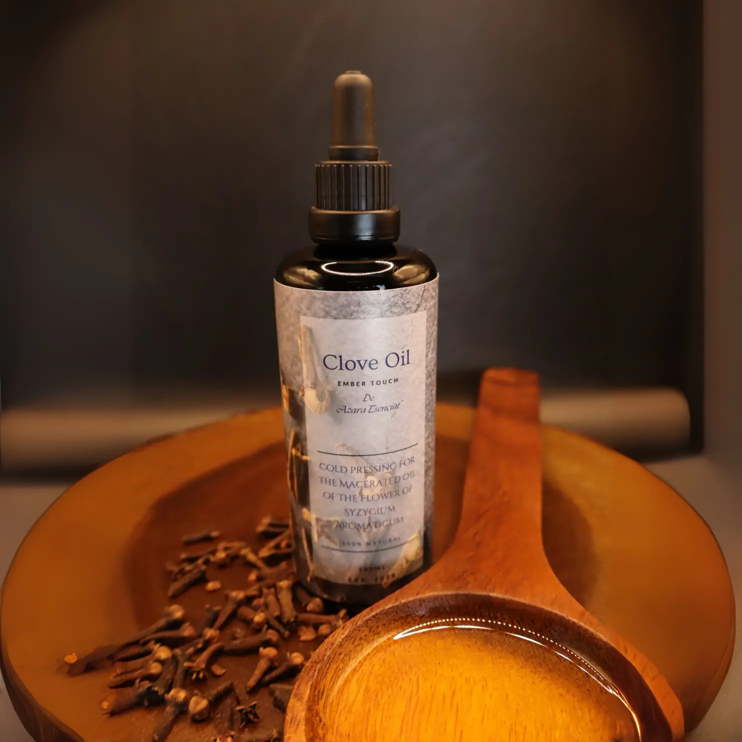 wooden-spoon-full-of-clove-oil- product shot with the bottle of clove oil in black background BY- azara natural