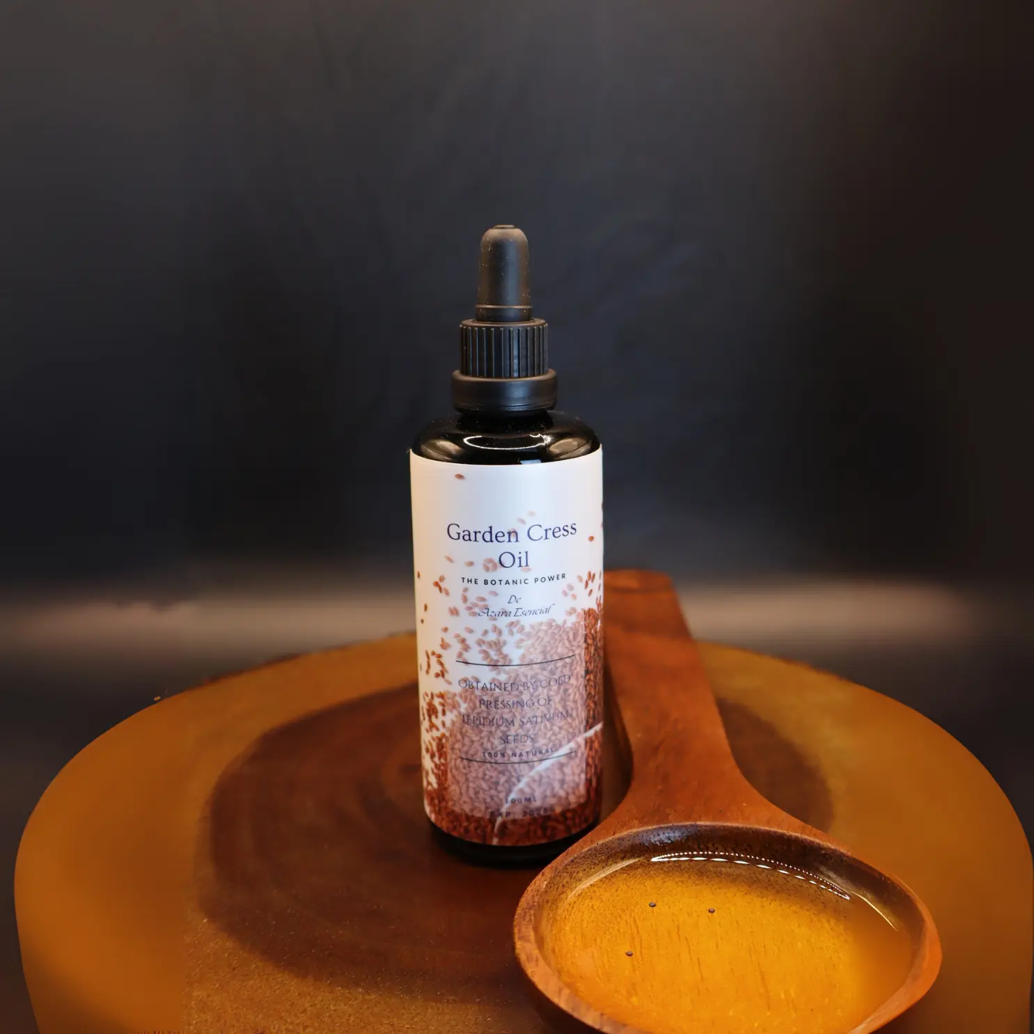 garden-cress-oil product shot with black background and wooden decorative spoon on wooden stand BY azara natural