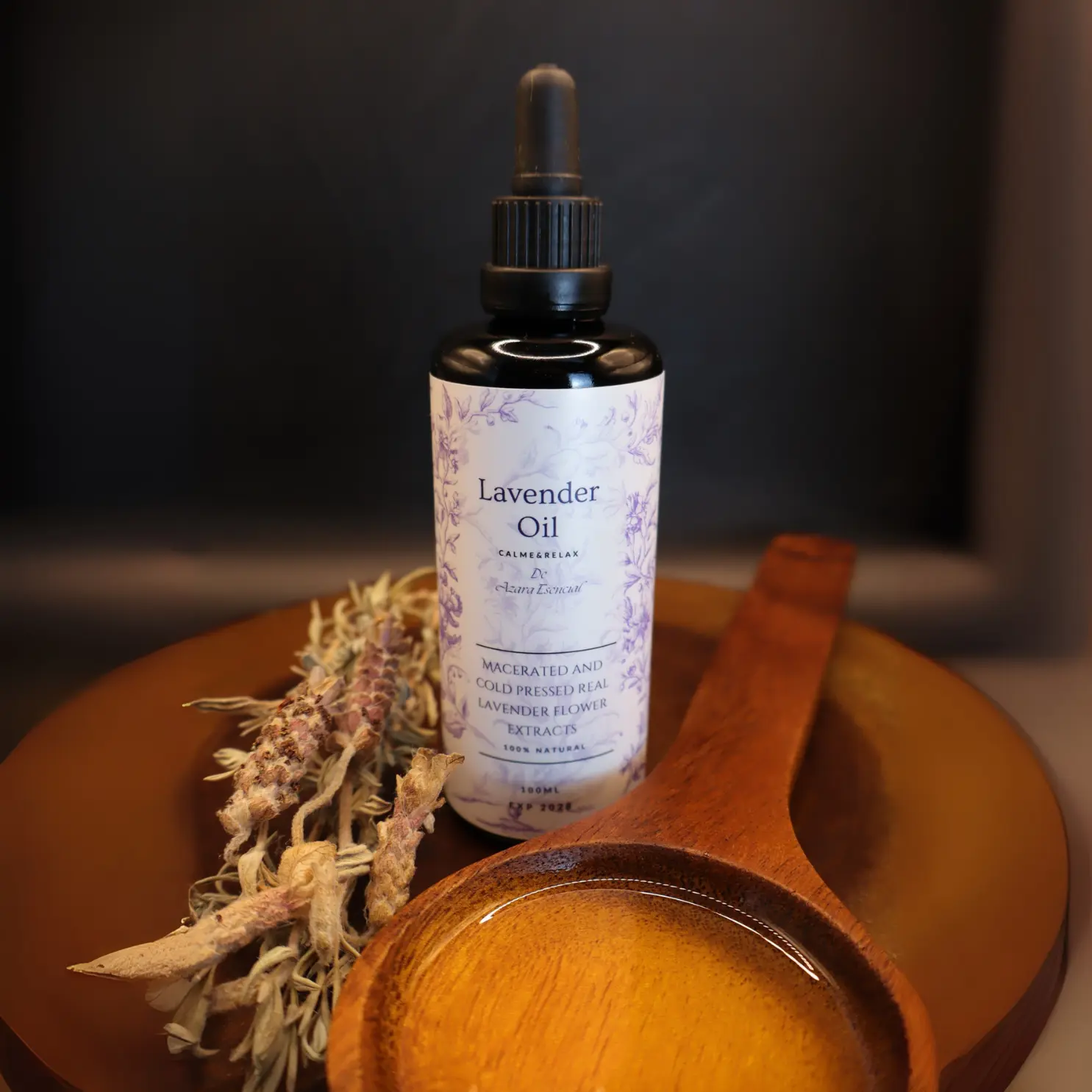 macerated-then-cold-pressed-lavender-oil-product shot with black background and a spoon of wood full of the oil with With a sprig of lavender. BY azara natural