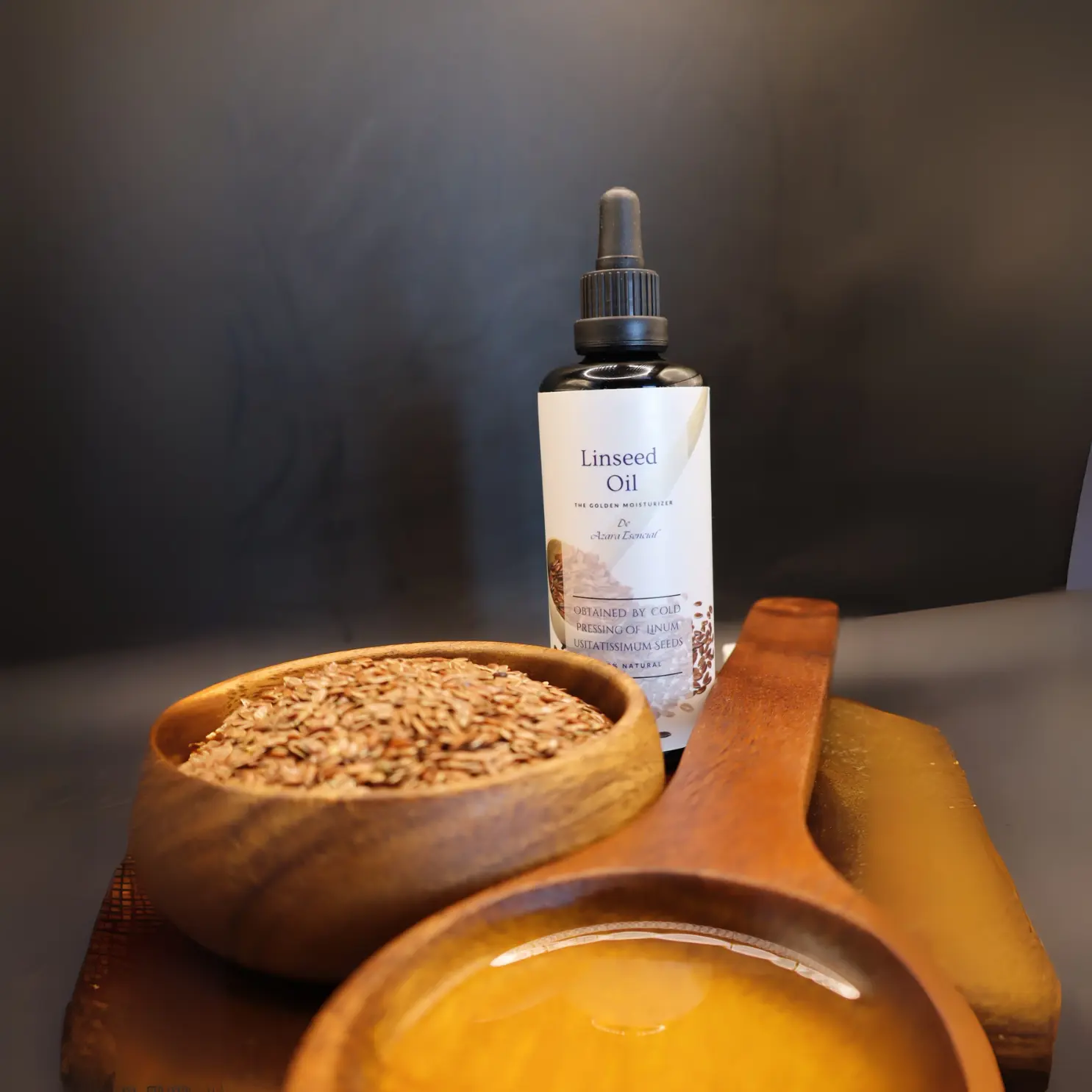 linseed oil By azara natural with wooden spoon of the oil and another full of linseeds with black background and circular wooden stand